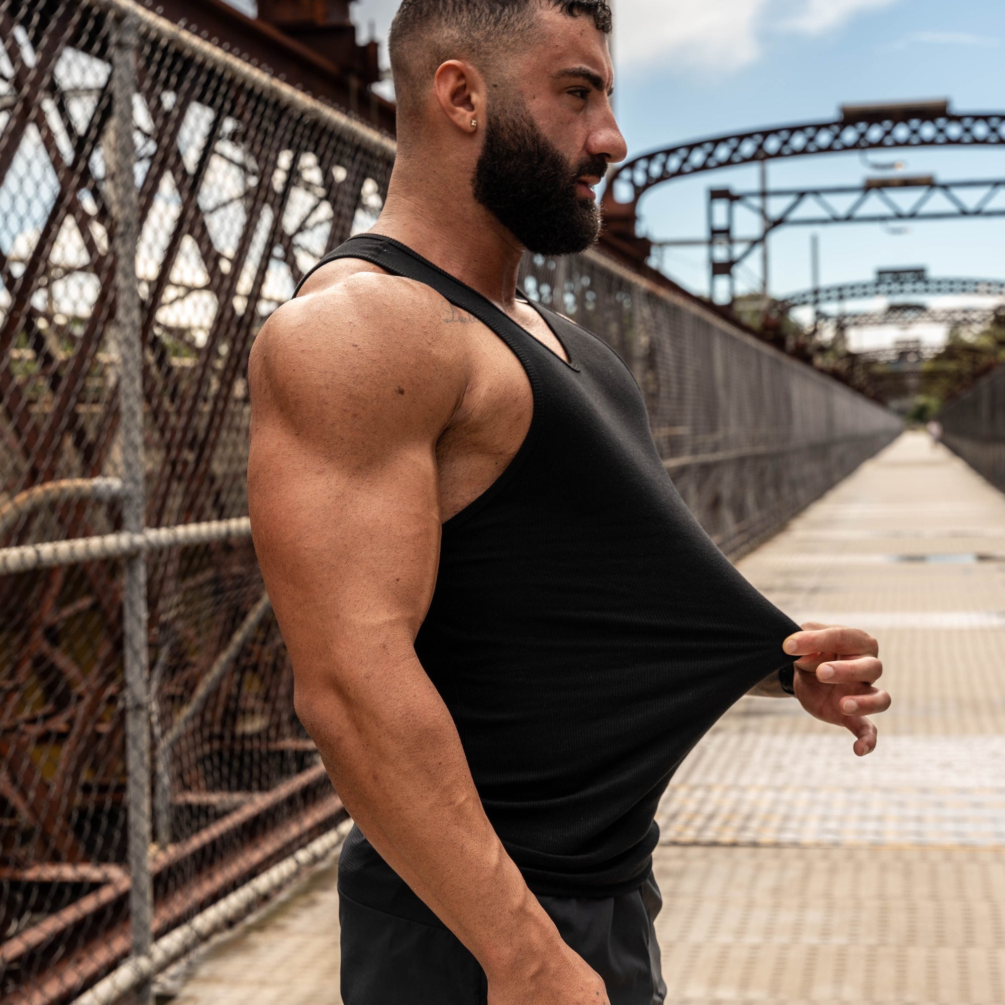 man stretching black Lionbuilt tank to show off premium cotton blend