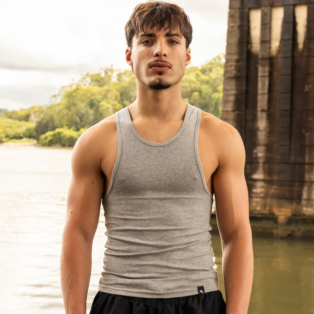 front pose showing muscular physique in LionBuilt grey tank top by water